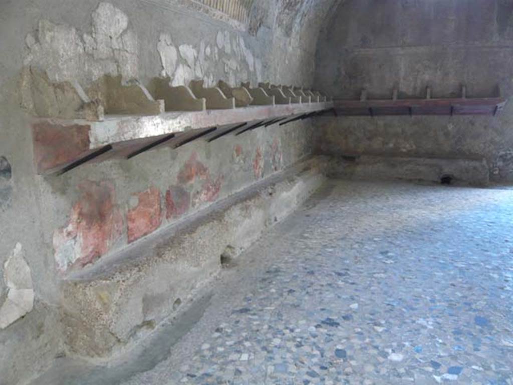 VI.1, Herculaneum. August 2013. Looking south along east wall of apodyterium with remains of a simple red dado. Photo courtesy of Buzz Ferebee.
Around three sides of the room was a plain podium for the seats, and the shelves with separate recesses for clothes and bath linen.